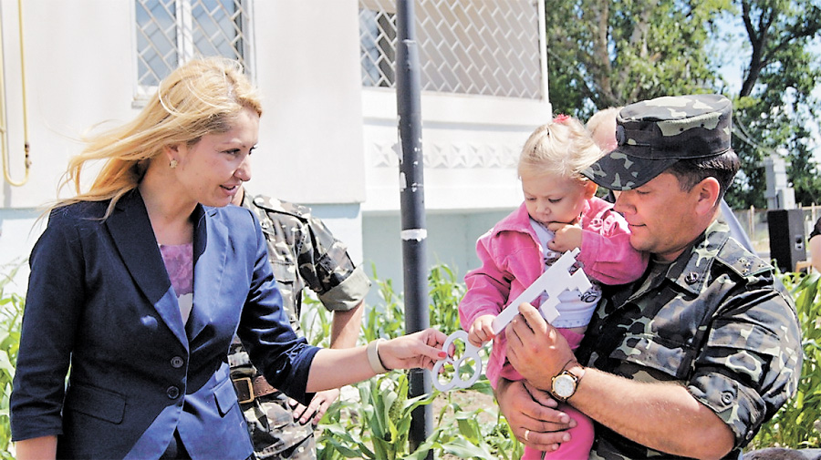 оксана Янішевська вручає символічний ключ від будинку. Родини військовослужбовців чекали власного житла понад десять років. Фото Світлани СКРЯБІНОЇ